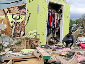 Leslie Harrington kneels down to help a former neighbour and family friend look for jewelry in her destroyed home along Seely Dr. outside of Hamilton, Miss., after a deadly storm moved through the area on Sunday, April 14, 2019.