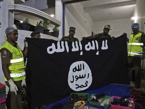 In this Friday, April 26, 2019, photo, Sri Lankan police officers show ISIS flag recovered from alleged hideout of militants, in Kalmunai, in Eastern Sri Lanka. (AP Photo)