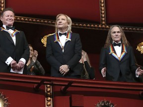 In this Dec. 4, 2016 file photo, members of the Eagles, from left, Don Henley, Joe Walsh, and Timothy Schmit, applaud during the Kennedy Center Honors Gala at the Kennedy Center in Washington.