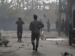 Sri Lankan security forces approach the site after a vehicle parked near St. Anthony's shrine exploded in Colombo, Sri Lanka, Monday, April 22, 2019.