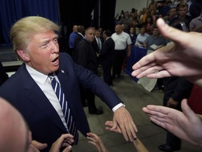 In this Aug. 11, 2015, file photo, Republican presidential candidate Donald Trump meets supporters after addressing a GOP fundraising event in Birch Run, Mich.