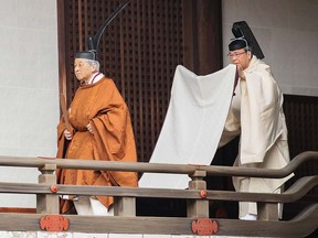 Japan's Emperor Akihito (left) walks to the Kashikodokoro imperial sanctuary inside the Imperial Palace to attend a ritual to report the conduct of his abdication ceremony in Tokyo on April 30, 2019. (STR / Japan Pool / AFP)