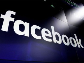 In this March 29, 2018, file photo the logo for social media giant Facebook, appears on screens at the Nasdaq MarketSite, in New York's Times Square. Facebook says it will use artificial intelligence to help find profiles of people who have died, so their friends and family members won't get, for instance, painful reminders about their birthday.