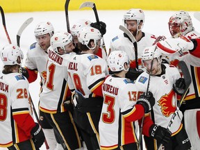 Calgary Flames goaltender Mike Smith celebrates a win against the San Jose Sharks with teammates in the third period of an NHL game in San Jose, Calif., Sunday, March 31, 2019.