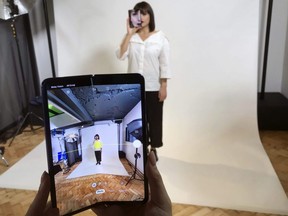 A model holds a Samsung Galaxy Fold smart phone to her face, during a media preview event in London on April 16, 2019.