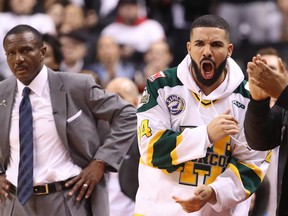 Rap artist Drake celebrates as head coach Dwane Casey of the Toronto Raptors looks on in the closing moments of their victory against the Washington Wizards in the first quarter during Game One of the first round of the 2018 NBA Playoffs at Air Canada Centre on April 14, 2018 in Toronto. (Tom Szczerbowski/Getty Images)