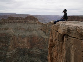 A tourist looks over the Grand Canyon at the Eagle Point site on the Hualapai Indian Reservation on March 27, 2019. (LARRY WONG/POSTMEDIA NETWORK)