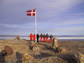The crew of Danish warship Vedderen perform a flag raising ceremony on the uninhabitated Hans Island off northwestern Greenland, in this Aug. 13, 2002 file photo.