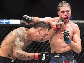 Max Holloway, left, fights Brian Ortega for the UFC featherweight championship title in Toronto on Sunday, December 9, 2018. (THE CANADIAN PRESS/Nathan Denette)