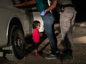 In this image released by the World Press Photo Foundation from John Moore, Getty Images, which won the World Press Photo of the Year and the first prize in the Spot News, Singles, category, titled "Crying Girl on the Border," shows Honduran toddler Yanela Sanchez crying as she and her mother, Sandra Sanchez, are taken into custody by U.S. border officials in McAllen, Texas on June 12, 2018.