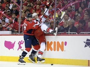 Washington Capitals defenceman John Carlson checks Carolina Hurricanes left wing Warren Foegele, right, into the boards during the first period of Game 7 of an NHL first-round playoff series, Wednesday, April 24, 2019, in Washington.