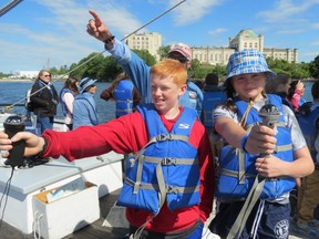 Laconia Middle School students Bree Ricker and Cody Newman use compasses aboard the ‘Piscataqua,’ a replica early 1900s gundalow cargo-hauler, as Gundalow Company educator-deck hand Rick Kaye-Scheiss offers advice — with long-closed former Portsmouth Naval Prison on Seavey’s Island, in Kittery, Maine, across the Piscataqua River from Portsmouth, N.H. (Ian Robertson)