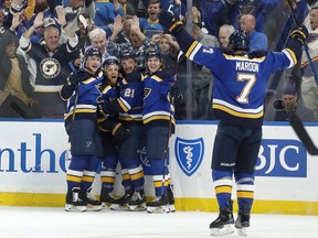 St. Louis Blues' Jaden Schwartz, second from left, is congratulated by teammates Vince Dunn, left, Tyler Bozak (21), Tyler Bozak and Pat Maroon (7) after scoring during the second period in Game 6 of an NHL first-round hockey playoff series against the Winnipeg Jets, Saturday, April 20, 2019, in St. Louis.