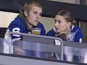 Justin Bieber watches alongside his wife Hailey Baldwin, right, during NHL action between the Flyers and Maple Leafs, in Toronto on Nov. 24, 2018.