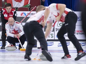 Switzerland skip Peter de Cruz watches over the shoulders of Canada skip Kevin Koe as a shot comes in during their semi-finals game at the world men's curling championship in Lethbridge, Alta. on Saturday, April 6, 2019.