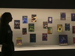 In this Wednesday Oct. 18, 2017 file photo, a member of British Library staff poses for a picture with Harry Potter books published in several languages at the "Harry Potter - A History of Magic" exhibition at the British Library, in London.