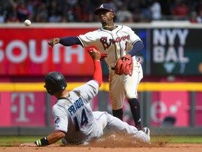 Atlanta Braves second baseman Ozzie Albies throws to first after forcing out Miami Marlins' Martin Prado during a game Sunday, April 7, 2019, in Atlanta.