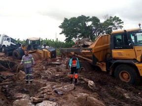In this photograph released by the Mozambique Red Cross, people inspect road damage in Nampula, Mozambique, Friday, April 26, 2019, after Cyclone Kenneth struck. Heavy rains lashed northern Mozambique on Saturday in the wake of Cyclone Kenneth as aid groups warned of possible flooding and mudslides in the days ahead. (Mozambique Red Cross via AP) ORG XMIT: XJD102