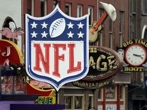 A temporary NFL neon sign joins the permanent ones along Broadway as preparation continues for the NFL Draft Tuesday, April 23, 2019, in Nashville, Tenn. The NFL Draft is scheduled to be held Thursday through Saturday.