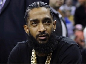 This March 29, 2018 file photo shows rapper Nipsey Hussle at an NBA basketball game between the Golden State Warriors and the Milwaukee Bucks in Oakland, Calif.