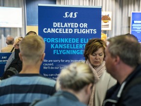 People queue after flights were cancelled by Scandinavian Airlines, at Oslo Airport in Gardermoen, Norway,  Friday, April 26, 2019.