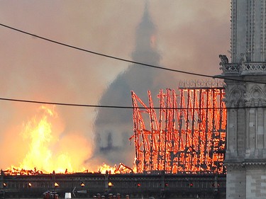 Smoke and flames rise during a fire at the landmark Notre Dame Cathedral in central Paris on April 15, 2019.