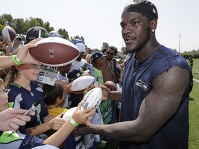 In this Aug. 6, 2018, file photo, Seattle Seahawks defensive end Frank Clark signs autographs following NFL football training camp, in Renton, Wash.