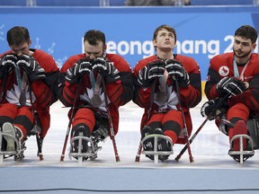 Canada's players, from left, Rob Armstrong, Tyler McGregor, Corbyn Smith and Ben Delaney react after receiving their silver medals from losing to the United States in their Ice Hockey gold medal match for the 2018 Winter Paralympics at the Gangneung Hockey Center in Gangneung, South Korea, Sunday, March 18, 2018.