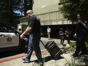 Police carry away items after investigating the apartment complex believed to be associated with a car crash suspect in Sunnyvale, Calif., on Wed., April 24, 2019. (AP Photo/Cody Glenn)