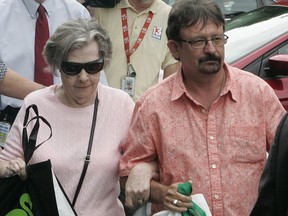 In this June 5, 2013 file photo, Powerball winner Gloria Mackenzie, left, leaves the lottery office escorted by her son, Scott Mackenzie, after claiming a single lump-sum payment of about $370.9 million before taxes in Tallahassee, Fla.