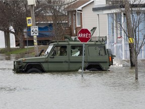 A military jeep moves through floodwaters on a closed street in Gatineau on April 23.