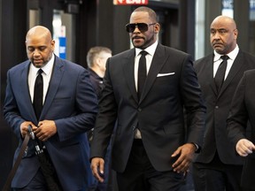 R. Kelly walks with attorneys into the Leighton Criminal Courthouse in Chicago on March 22, 2019.