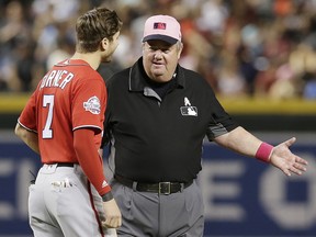 In this May 13, 2018, file photo, MLB umpire Joe West, right, talks with a player in Phoenix. (AP Photo/Rick Scuteri, File)