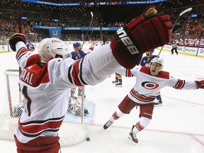 Jordan Staal of the Carolina Hurricanes scores at 4:04 of overtime against the New York Islanders and is joined by Teuvo Teravainen in Game 1 of the Eastern Conference Second Round during the 2019 NHL Stanley Cup Playoffs at the Barclays Center on April 26, 2019 in New York City.