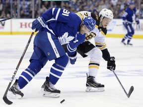 Maple Leafs centre John Tavares battles for the puck with Boston Bruins defenceman Charlie McAvoy.