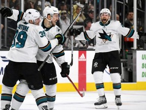 Sharks forward Logan Couture, left, Tomas Hertl, centre, and Barclay Goodrow, right, celebrate after Hertl scored a game-winning short-handed goal in the second overtime period of Game Six of the Western Conference first round playoff series at T-Mobile Arena in Las Vegas on Sunday, April 21, 2019.