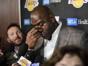 Magic Johnson wipes his eyes as he speaks to reporters prior to an NBA basketball game between the Los Angeles Lakers and the Portland Trail Blazers on Tuesday, April 9, 2019, in Los Angeles.