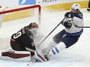 Winnipeg Jets forward Blake Wheeler (right) gives Arizona Coyotes goaltender Calvin Pickard a face full of ice spray. (AP)