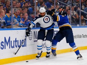 Jay Bouwmeester of the St. Louis Blues knocks Dustin Byfuglien of the Winnipeg Jets off the puck in Game 6 of the Western Conference First Round during the 2019 NHL Stanley Cup Playoffs on Saturday in St. Louis.