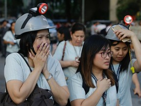 Wearing protective helmets, employees evacuate their office building following an earthquake in Manila, Philippines, on Monday, April 22, 2019.