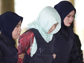 Vietnamese Doan Thi Huong, centre, is escorted by police as she arrives at Shah Alam High Court in Shah Alam, Malaysia, Monday, April 1, 2019.