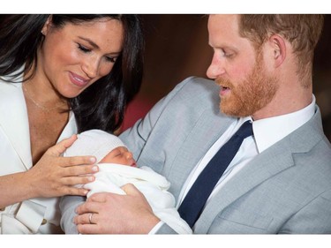 Prince Harry, Duke of Sussex, and his wife Meghan, Duchess of Sussex, pose for a photo with their newborn baby son, Archie Harrison Mountbatten-Windsor, in St George's Hall at Windsor Castle in Windsor, west of London on May 8, 2019.