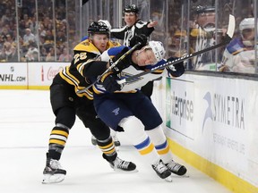 St. Louis Blues' Jay Bouwmeester gets checked by Boston Bruins' Brandon Carlo during Monday's game.