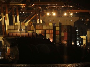 Containers are moved inside the cargo ship M/V Bavaria as it is docked at Subic port in Zambales province, northwestern Philippines on Thursday, May 30, 2019.  (AP Photo/Aaron Favila)