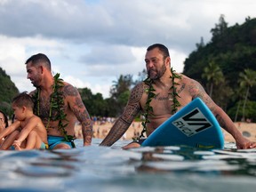 In this file photo taken on Nov. 29, 2018, Hawaii's pro surfer Billy Kemper, left, and former surfing world Champion Sunny Garcia, right, take part in the opening ceremony of the 2018 Eddie Aikau Big wave Invitational Surfing Event at Waimea Bay on the north shore of Oahu in Hawaii. (BRIAN BIELMANN/AFP/Getty Images)