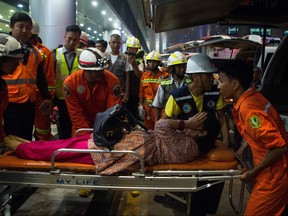 Rescue workers transport an injury passenger on a stretcher after a passenger aircraft of Biman Bangladesh Airlines slipped off a runway at Yangon International airport in Yangon on May 8, 2019. (MYO KYAW SOE/AFP/Getty Images)