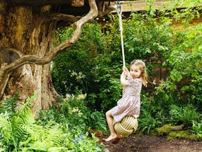 A picture released by Kensington Palace on May 19, 2019 shows Princess Charlotte swinging in the Adam White and Andree Davies co-designed 'Back to Nature' garden ahead of the RHS Chelsea Flower Show in London.