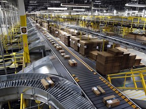 In this Aug. 3, 2017, file photo, packages ride on a conveyor system at an Amazon fulfillment center in Baltimore. Amazon, which is racing to deliver packages faster, is turning to its employees with a proposition: Quit your job and we'll help you start a business delivering Amazon package. The offer, announced Monday, May 13, 2019, comes as Amazon seeks to speed up its shipping time from two days to one for its Prime members.