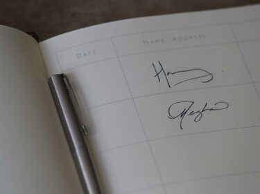 In this Wednesday, Oct. 3, 2018 file photo the signatures of Prince Harry and Meghan, Duchess of Sussex are written in the visitors book at Edes House in Chichester, south east England.