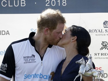 In this Thursday, July 26, 2018 file photo, Meghan, Duchess of Sussex and Britain's Prince Harry kiss during the presentation ceremony for the Sentebale ISPS Handa Polo Cup at the Royal County of Berkshire Polo Club in Windsor, England.